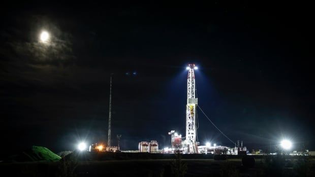 A white oil rig in the dark.