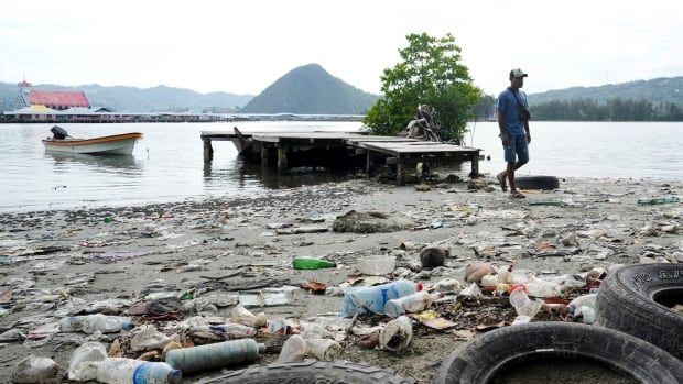 A man walks past plastic waste