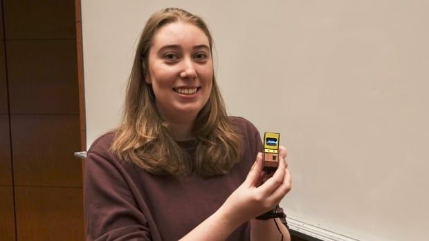 A woman holds a tiny arcade machine