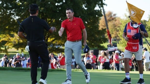 Two golfers shake hands.