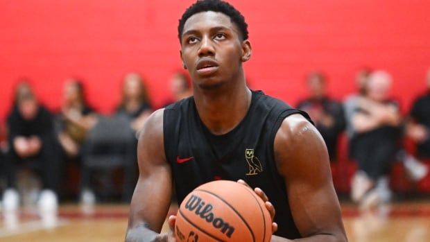 A basketball player prepares to shoot.