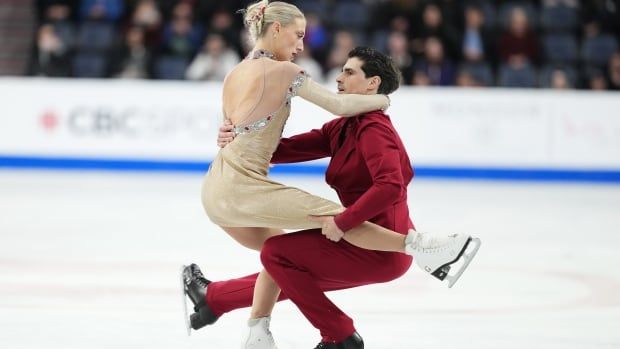 Two figure skaters compete.