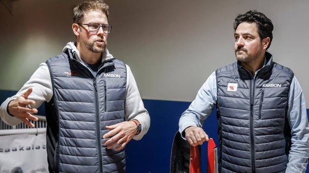 Bobsleigh Canada head Jesse Lumsden and Luge Canada head Sam Edney pose with the tools of their sport in Calgary on Oct. 29, 2024. 