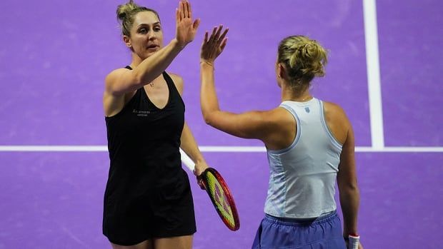 Canadian tennis player Gabriela Dabrowski and New Zealand's Erin Routliffe high-five during their women's doubles semifinal against Nicole Melichar-Martinez of the United States and Australia's Ellen Perez at the WTA Finals in Riyadh, Saudi Arabia. 