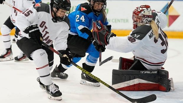 Ottawa goalie Emerance Maschmeyer and Toronto's Natalie Spooner look on as Ottawa's Savannah Harmon clears the puck during a Professional Women's Hockey League game in Toronto on May 5, 2024.