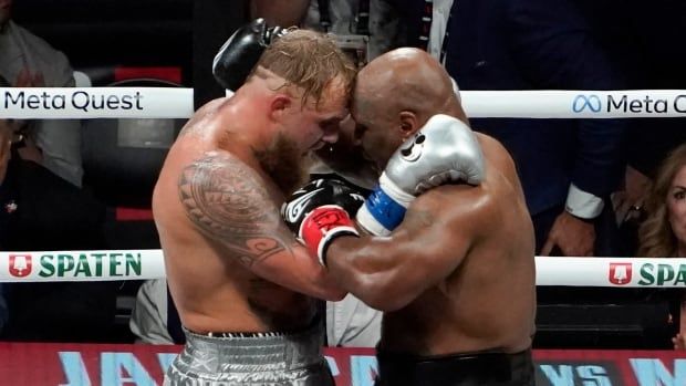 Two men's boxers hug in the ring at the end of a boxing match.