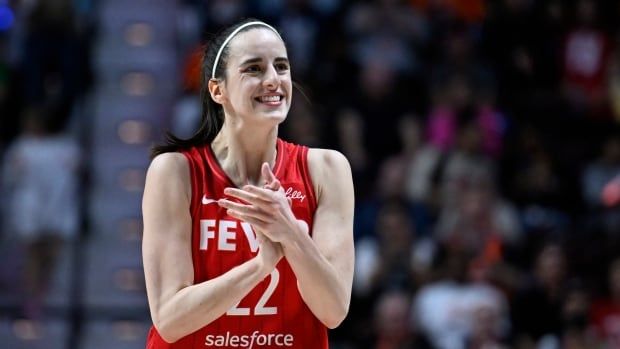 A women's basketball player claps during a game.