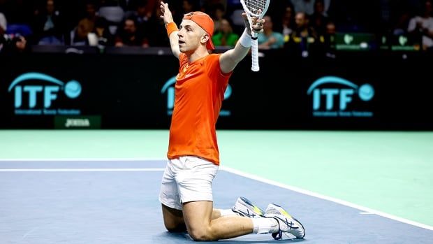 Tallon Griekspoor of the Netherlands kneels on the court and raises both arms, a tennis racket in his left hand, in celebration after winning in his singles semifinal over Germany’s Jan-Lennard Struff at the Davis Cup on Nov. 22, 2024 in Malaga, Spain. 