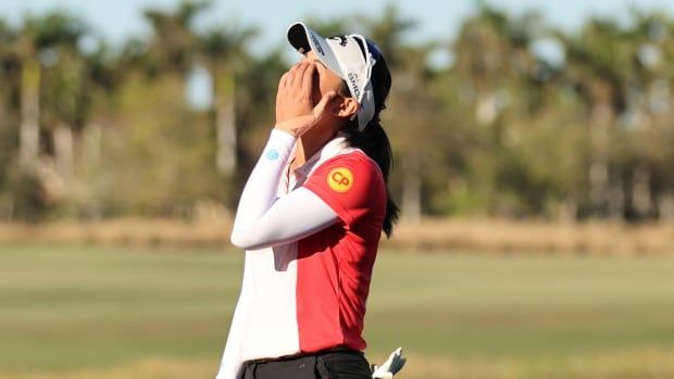 A woman reacts after making a putt.