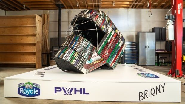 An enormous goalie mask made of hockey sticks