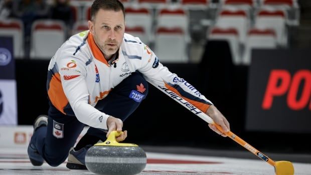 A men's skip delivers a stone during a match.