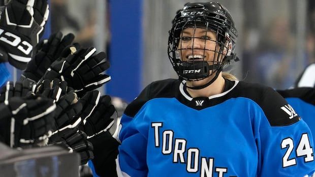 women's hockey player celebrating a goal