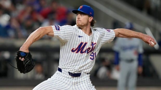 A male baseball pitcher throwing a pitch.