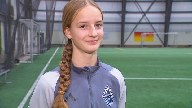 Girl with braid at indoor soccer pitch.