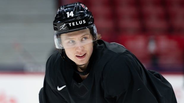 A hockey player looks on.