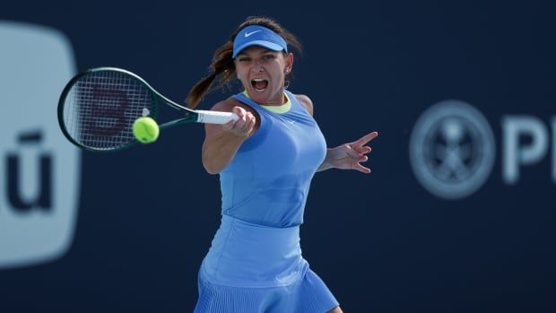 A tennis player hits a forehand.