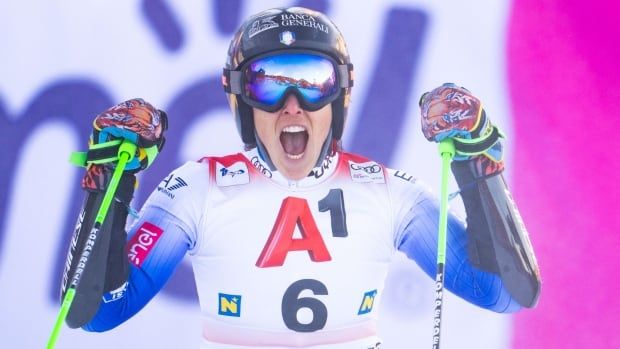 A female alpine skier yells in celebration.