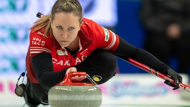 Female curler throws curling rock