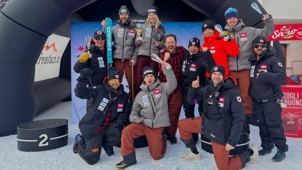 A group of Paralympic alpine skiers smile while holding up trophies as they pose for a picture.