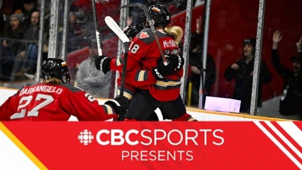 Three women's hockey players celebrate after scoring a goal.