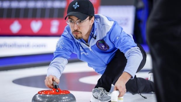 A man throws a curling tone.