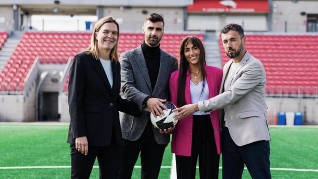 A group pose for a picture holding a ball.