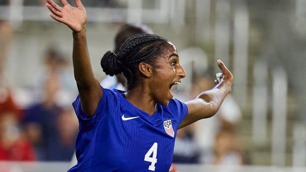 American women's soccer player Naomi Girma raises her arms in celebration after a scoring the team's first goal during the first half of an Oct. 30, 2024  international friendly against Argentina at Lynn Family Stadium in Louisville, Kentucky. 