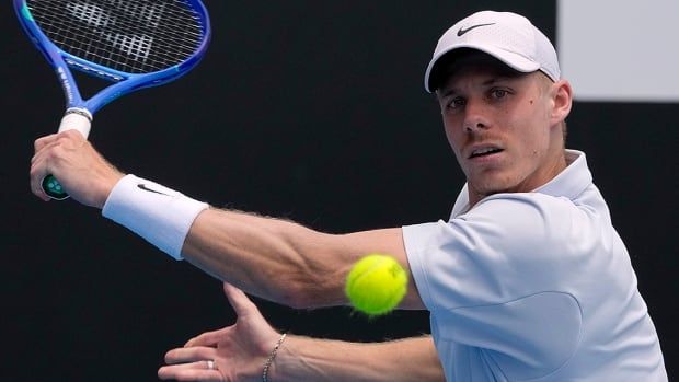 Canadian men's tennis player Denis Shapovalov plays a backhand return to Lorenzo Musetti of Italy during their second-round match at the Australian Open in Melbourne on January 16, 2025.  