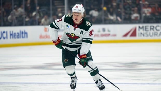 A male hockey player skates during a game.