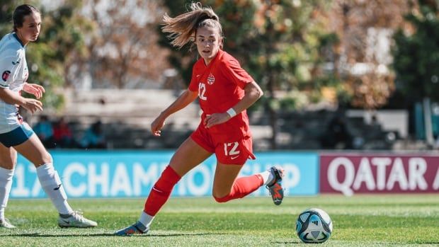 Two women's soccer players vie for the ball.