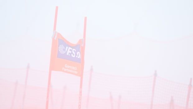 A skiing gate is shrouded in fog.