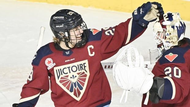 Women's hockey teammates embrace after a game.