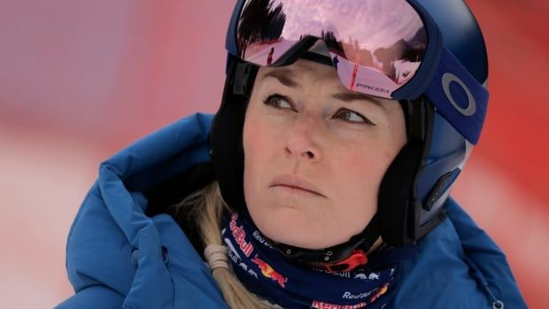 A female alpine skiier looks on ahead of an alpine ski.