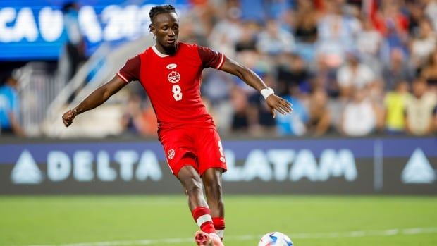 A male soccer player moves the ball and ready to strike.