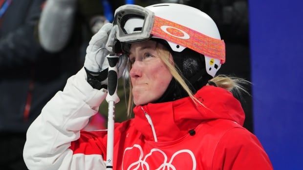 A female mogul skier reacts to her result.