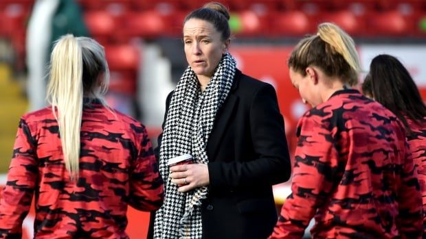 A female soccer manager talks to players.