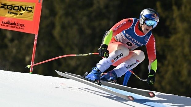 A men's slpine skier is shown after navigating a gate and with both skis just off the snow.