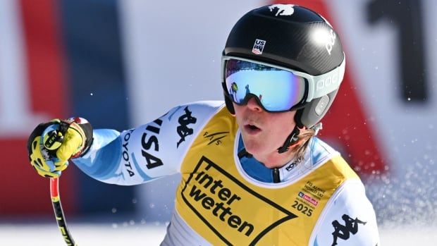 A women's skier cheers as she carves to a stop at the end of the course.