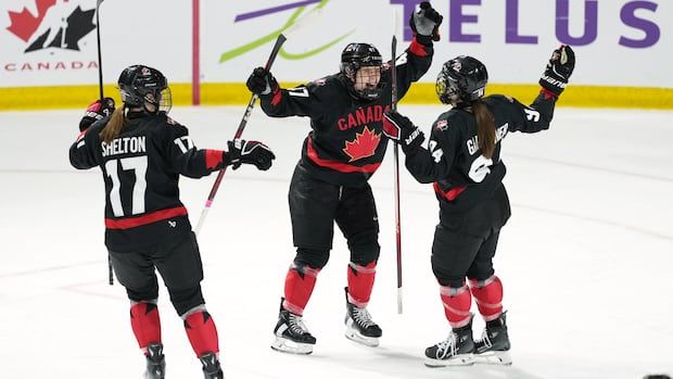 Team Canada's Ella Shelton, Jamie Lee Rattray, and Jennifer Gardiner celebrate Gardiner's goal during the third period of Rivalry Series action.