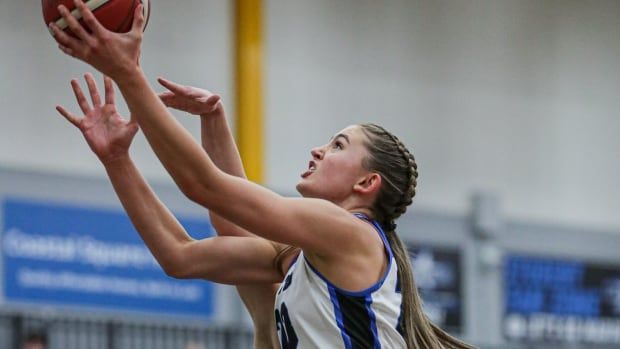 A college basketball player attempts a layup.