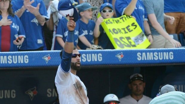 A men's baseball player waves to a crowd.