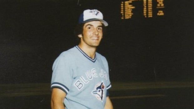 A smiling man wearing a Toronto Blue Jays uniform