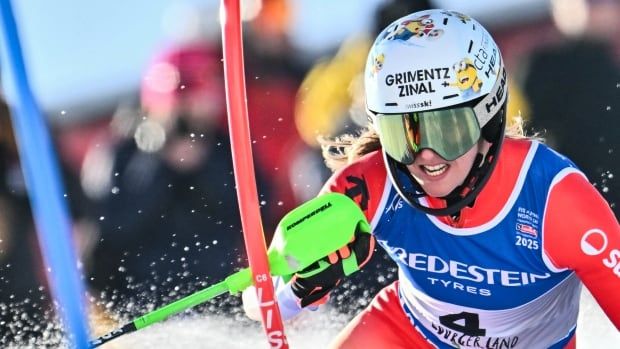 A women's skier is shown with red and blue gates in the foreground.