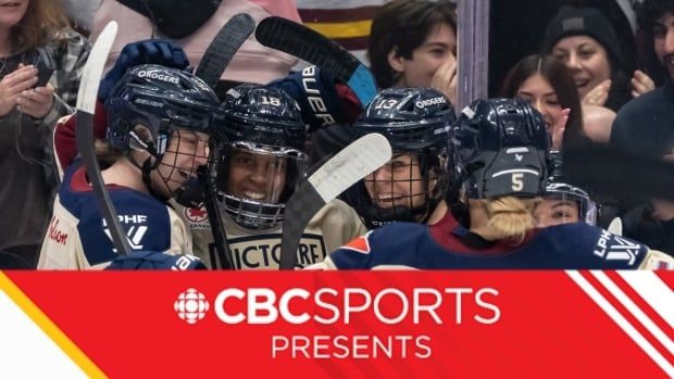 A group of women's hockey players celebrate together.