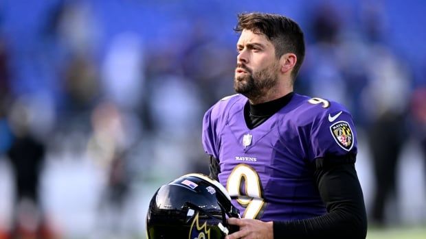 A men's football kicker looks on during a game.