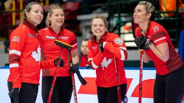 A curling team share a smile during a match.