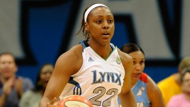 A women's basketball player dribbles the ball during a game.