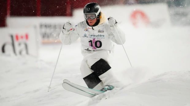 A men's moguls skier is shown in competition.