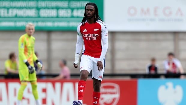 Male soccer player controls soccer ball on field during play.