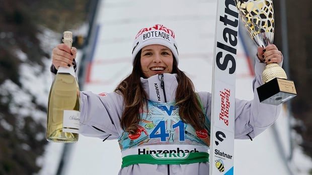 Canadian ski jumper Abigail Strate holds the winner’s trophy after finishing the women’s normal-size hill competition in third place in Hinzenbach, Austria on February 23, 2025. 